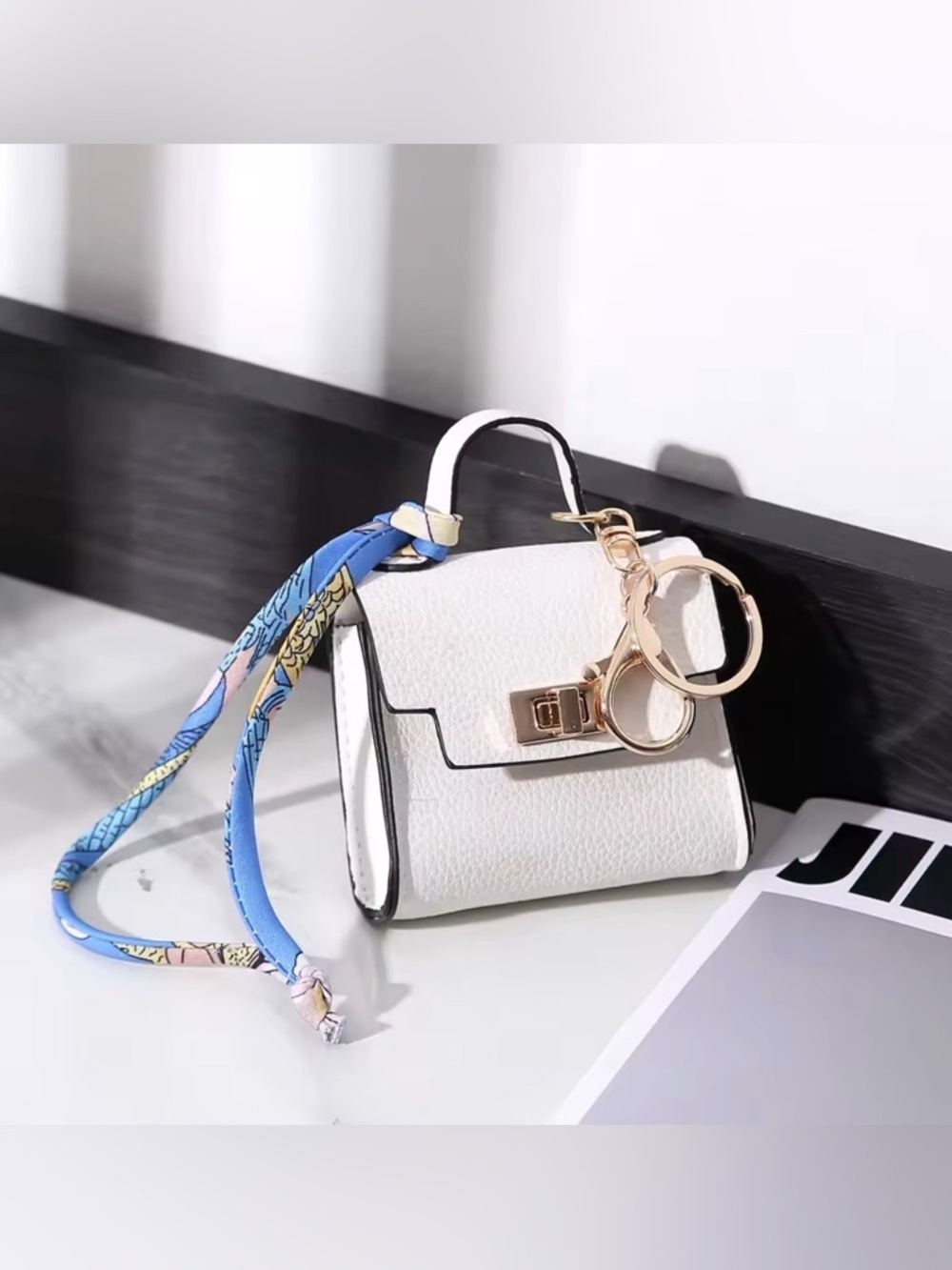 White Mini Bag Charm Accessory with Gold Hardware and Blue Scarf Accent